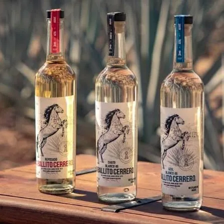 Tres botellas de Caballito Cerrero sobre una mesa de madera